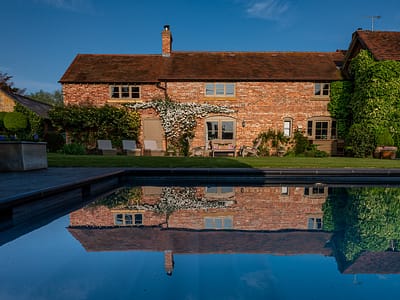 Pool reflection lower farm house with pool near wilderness festival